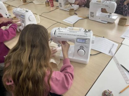 Child sewing a tote bag