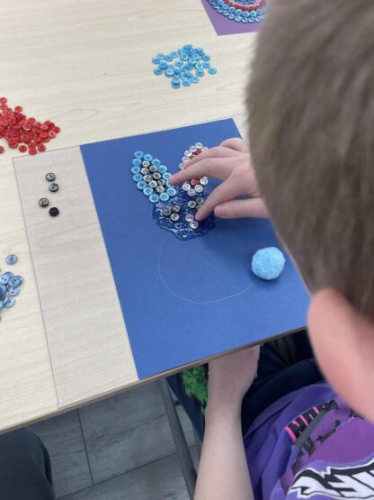 Child creating button art