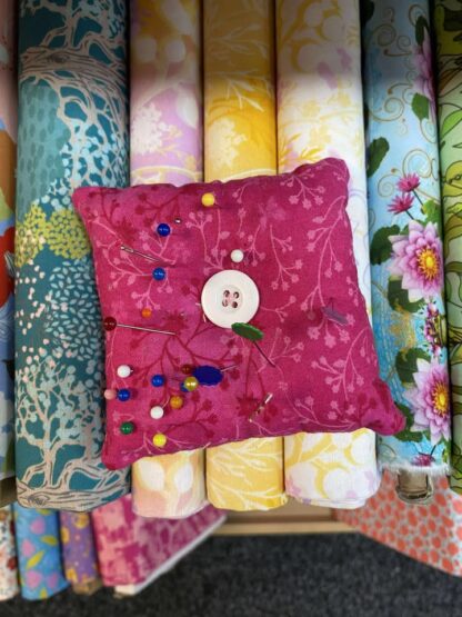 Pin cushion placed onto fabric bolts