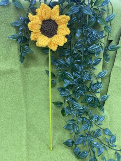 Crocheted sunflower with yarn wound stem
