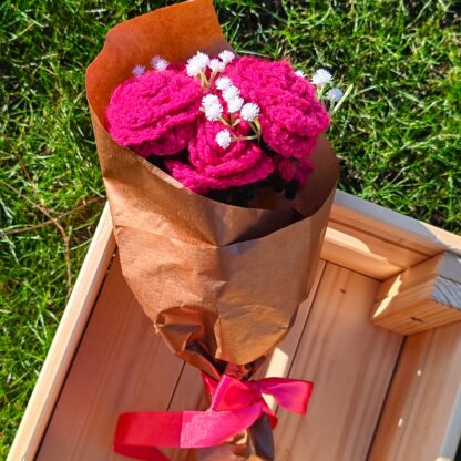 Crochet roses displayed in a wooden box