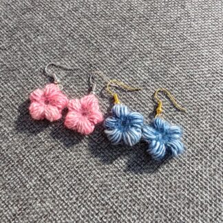 A pair of blue and pink crocheted flower earrings, attached to ear wires.
