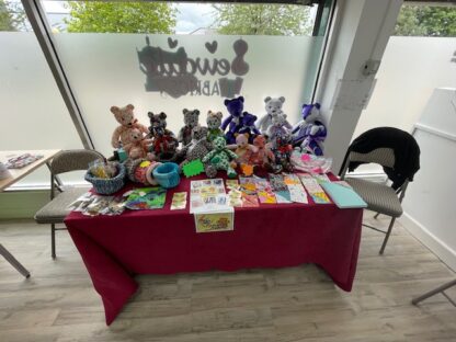 a selection of handmade memory bears for sale at a community craft fair