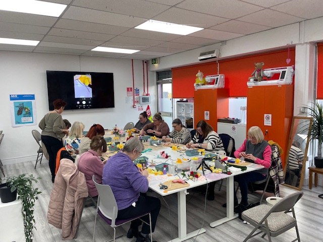 a group of people making paper flowers on a workshop at sew mindful crafts